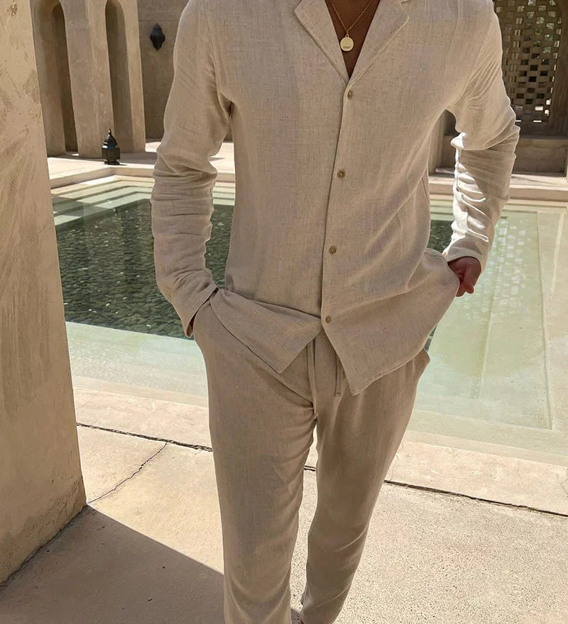 Mann trägt beiges Sommer-Set aus Leinen mit lockerem Hemd und Hose, vor modernem Pool – ideal für warme Tage und stilvolle Freizeitlooks